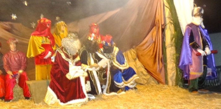 Los tres Reyes Magos, enfrascados en la lectura, por ambas caras, de una carta. A la derecha, su Prncipe Aliatar, con el pergamino del mensaje que ley.