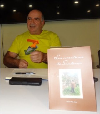 Primer plano de Alberto  Prida con su libro Les aventures de Santones